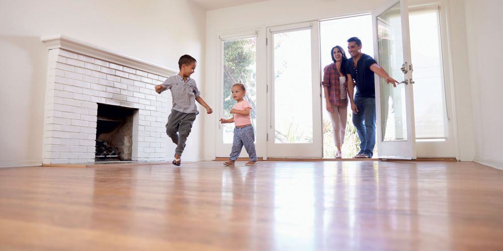 Family moving to a newly renovated home while walking through the main entrance of a home
